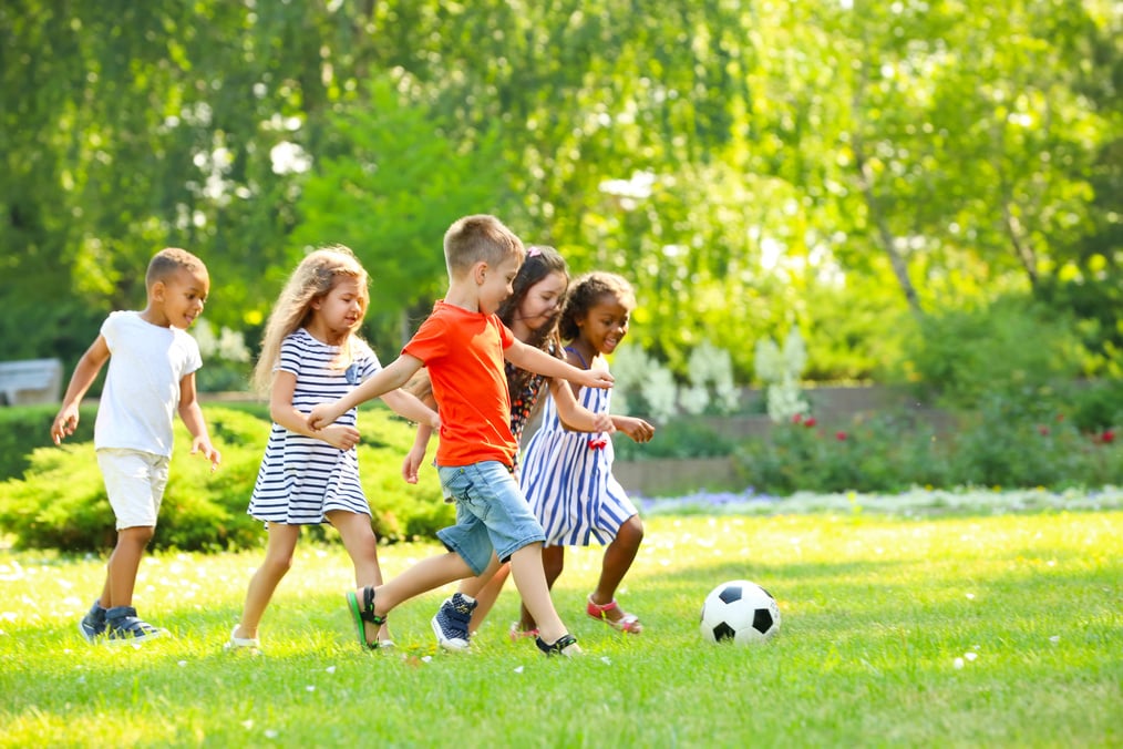 Cute Little Children Playing Football Outdoors